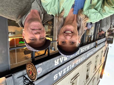 A couple outside a pizza bar.