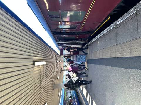 People boarding a train at a railway station.