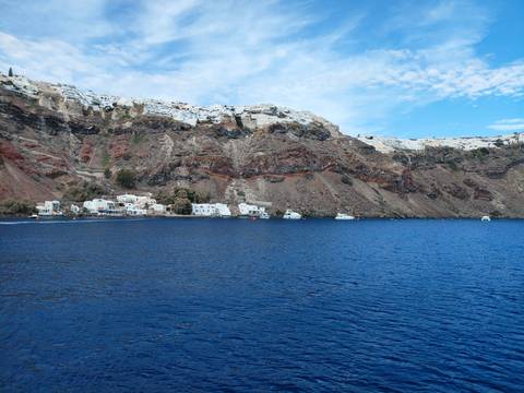 Scenic seaside village with white buildings on rocky cliff.