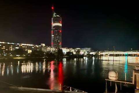       City skyline at night with lights reflecting on water
  