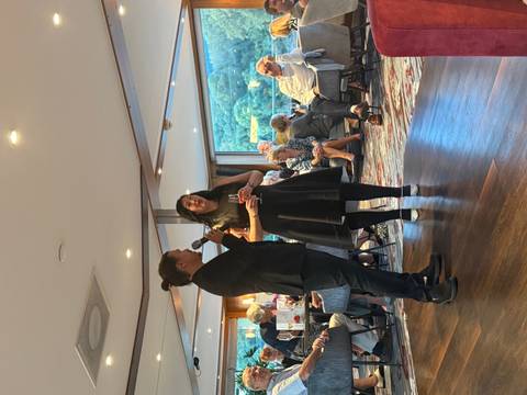       Two people speaking to an audience at an event
  