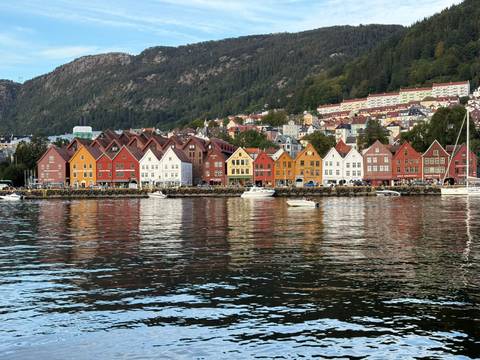 Colorful houses reflecting in the water by a mountain.