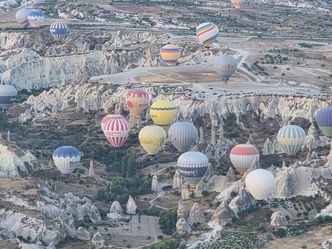 Hot air balloons over rocky terrain.