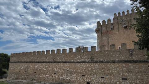Ancient fortress walls under a partly cloudy sky.