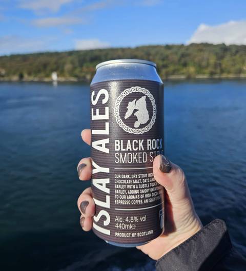       Close-up of a beer can labeled 'Black Rock Smoked Stout' held against a blurry background.
  