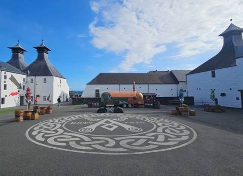 Courtyard with the Ardbeg distillery logo and symbols on the ground.