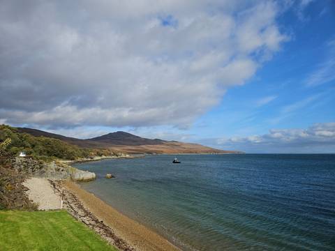 Coastal landscape with a vast view of the sea and hills.