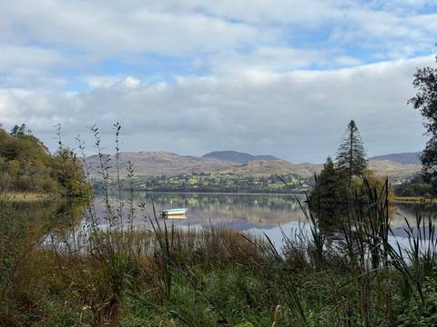 Calm lake with a boat and distant hills.