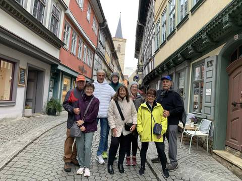       A group of people posing in an old town street.
  