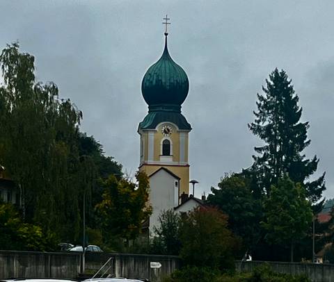 A countryside church with a green onion dome.