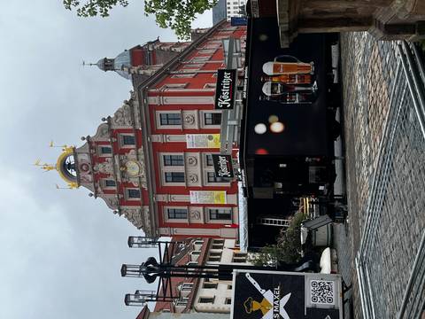       Market square with a historic building and beer advertising.
  