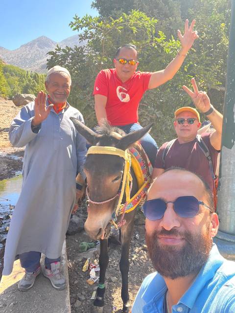       Group photo with a donkey ride and people smiling.
  