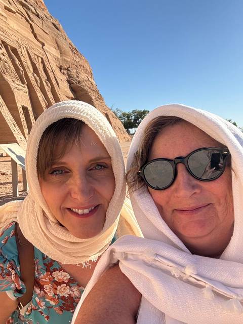 Two women with headscarves smiling at the camera.