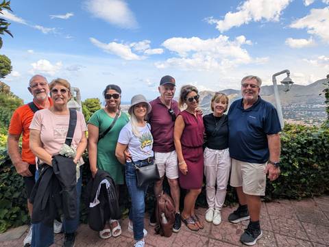       Group of tourists posing with a scenic backdrop
  