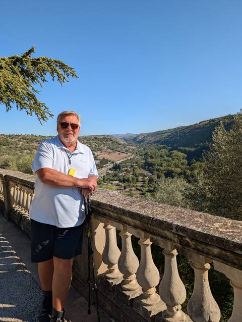       Older man standing with a valley view in the background
  