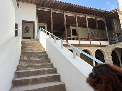 Staircase leading to a historic white building with wooden elements.