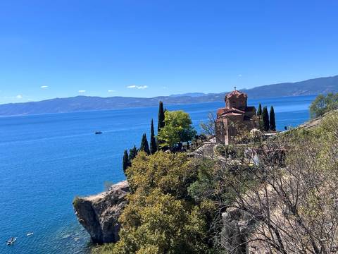 Church on a cliff overlooking a large blue lake.