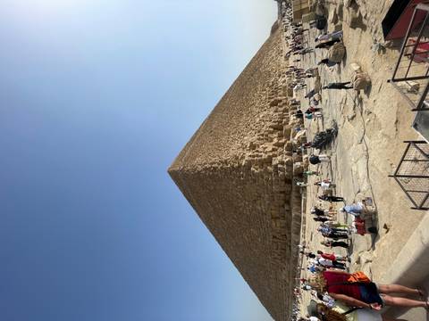 Crowds of people around the base of a large pyramid.