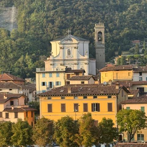       A mix of colorful historic buildings and a church on a hill.
  