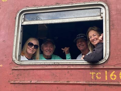 Group inside a train looking out through a window.