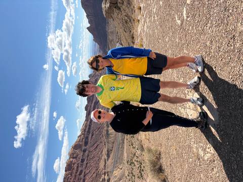 Three people posing with canyon view in the background.