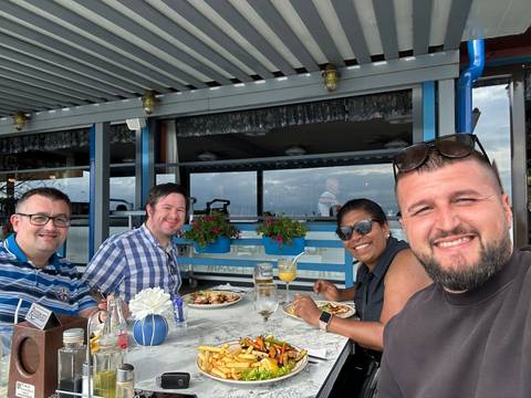       Group of people dining at an outdoor restaurant.
  