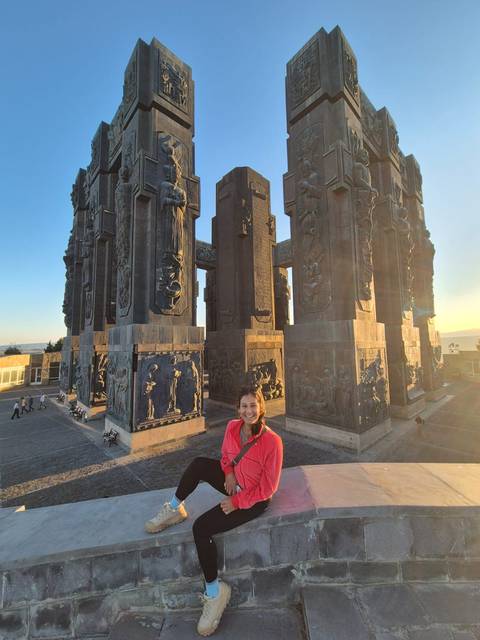 Person standing by monument with intricate carvings.
