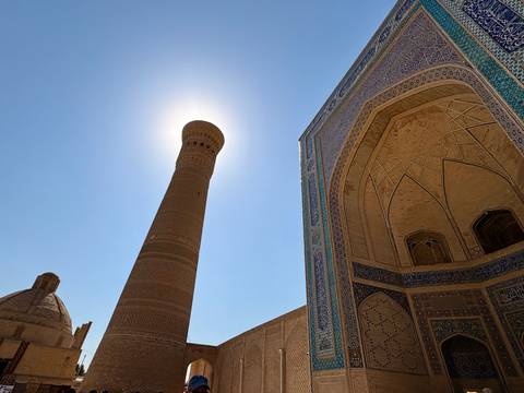       Silhouette of a minaret against a bright sky.
  