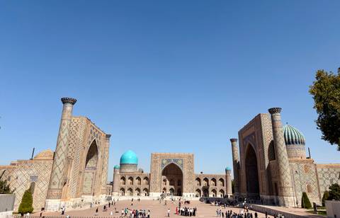       Panoramic view of a vibrant, historic square with blue domes.
  