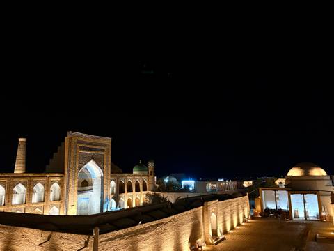       Night view of illuminated historical buildings.
  