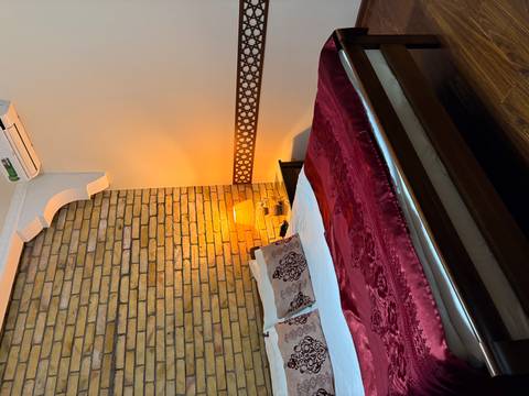       Cozy bedroom with a brick wall and warm lighting.
  
