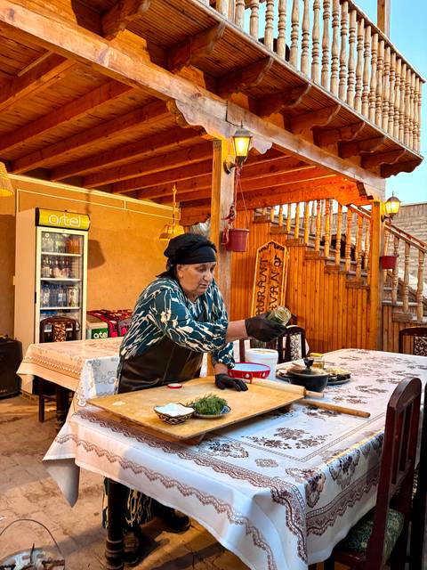       Woman preparing food in a rustic setting.
  
