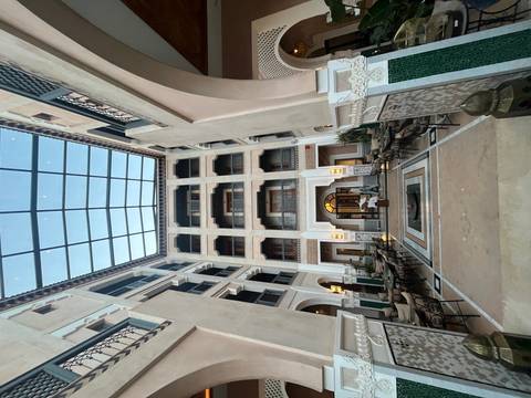A courtyard of a traditional riad with a glass ceiling and decorative tiles.