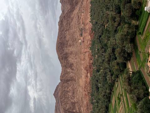       A scenic view of a lush green valley and mountains in the background.
  