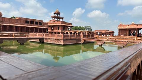 Historic sandstone structure with a reflecting pool.