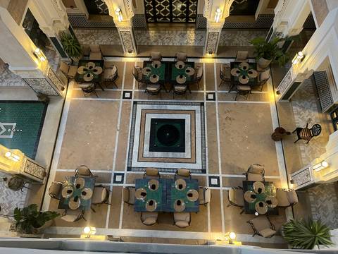 Top-down view of a courtyard with seating arrangements and decorative tiles.