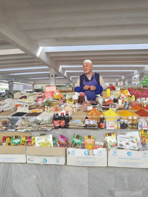 Market scene with a vendor and various spices.