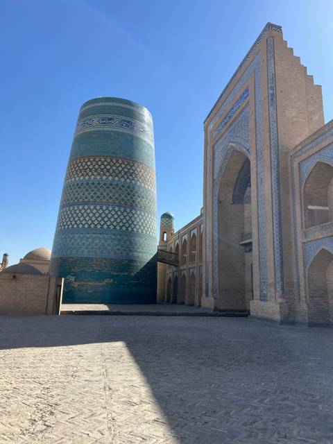 Large blue-tiled minaret and buildings.