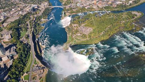       Aerial view of Niagara Falls with surrounding landscape.
  