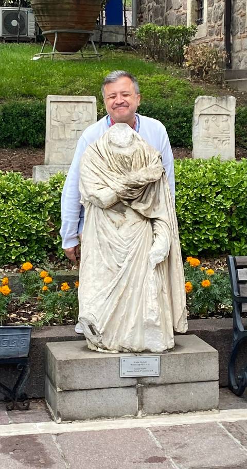 A statue surrounded by blooming flowers.