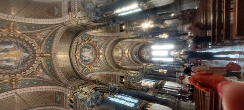 Interior of an ornate church with people inside.