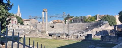Ancient Roman amphitheater with columns and seating.