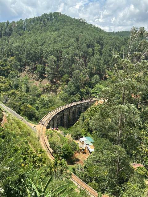 Nine Arches Bridge nestled within an emerald green forest.