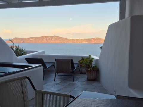 Mediterranean style patio with lounge chairs overlooking the sea.
