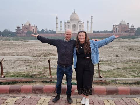 Tourists in front of the Taj Mahal, seen from a distance.