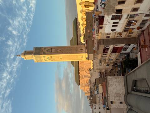       View of a tower in a city with housing in the foreground.
  