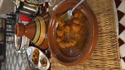       Moroccan dish with a tagine on a table set for dinner.
  