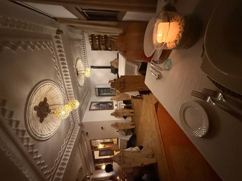       Interior of a restaurant with traditional decor and candlelit tables.
  