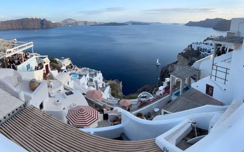 Panoramic view of white buildings on a cliffside overlooking the sea.