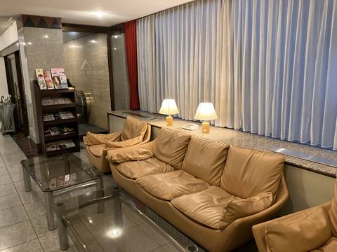 Hotel lobby area with seating and a rack of brochures.